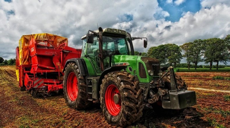 Imagen de un tractor realizando tareas de cultivo tras alquilar en suelo rústico