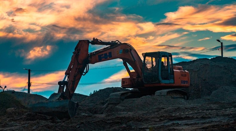 Multas por construir en terreno rústico. Imagen de una excavadora en una construcción en terreno rústico