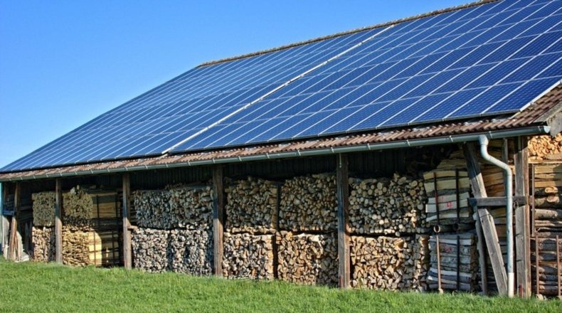Ayudas para la instalación de placas solares en un terreno. Imagen de placas solares en el techo de un granero.